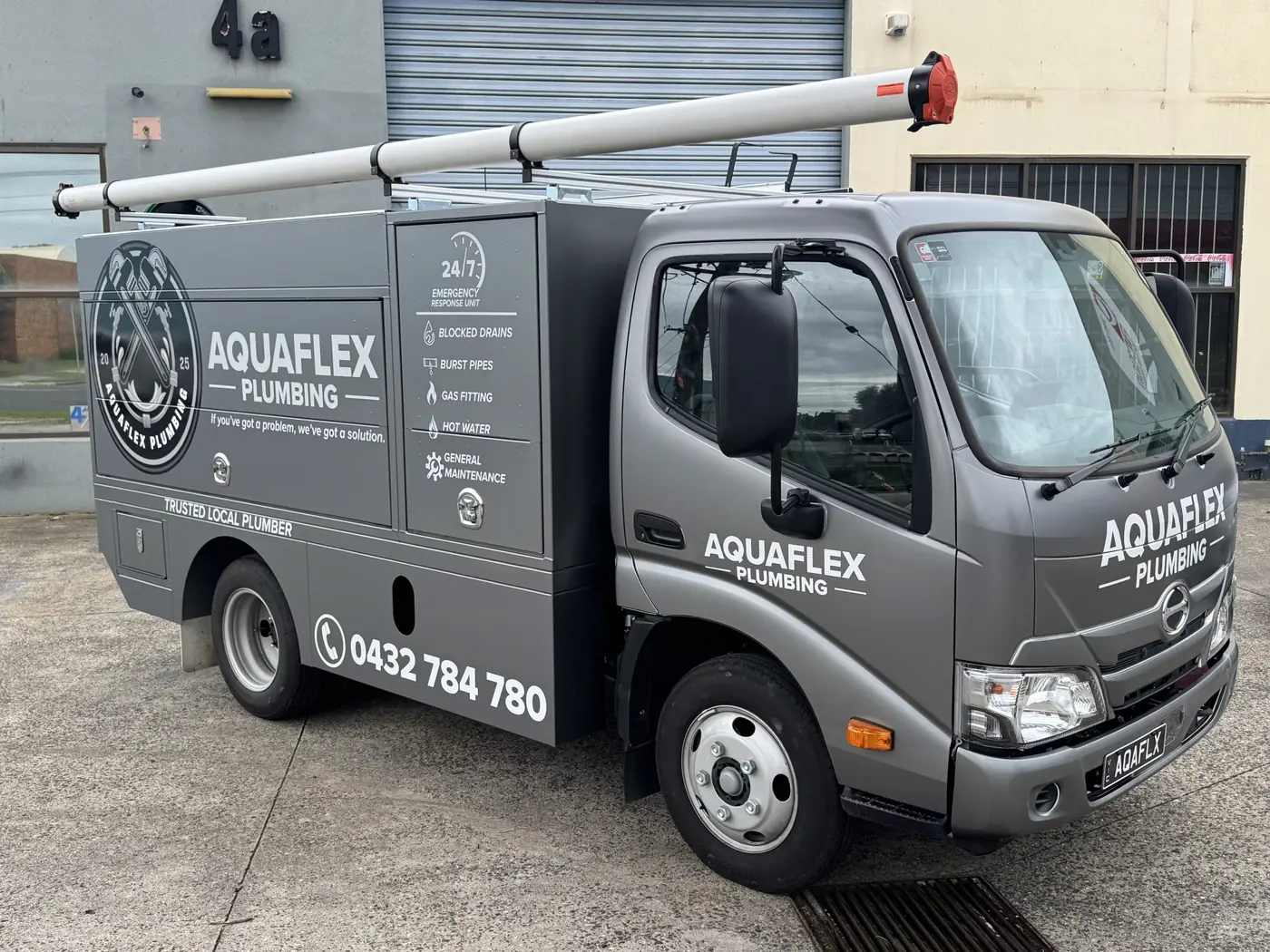 The Aquaflex Plumbing ute with the badge logo and phone number on the side