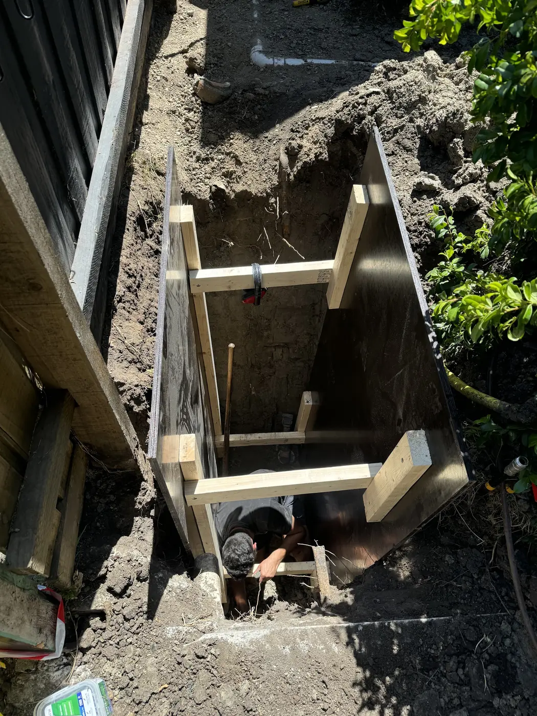 Timber-shored excavation down to a boundary trap