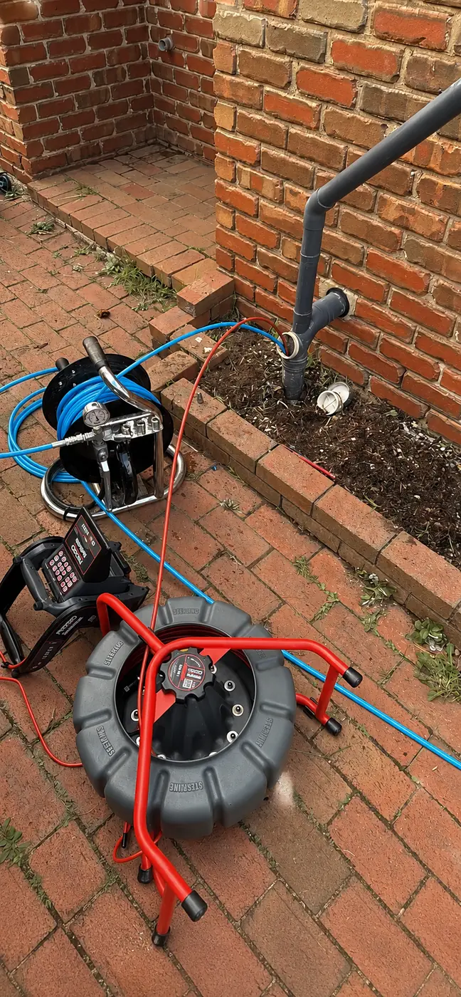 Drain inspection camera reel on a brick path