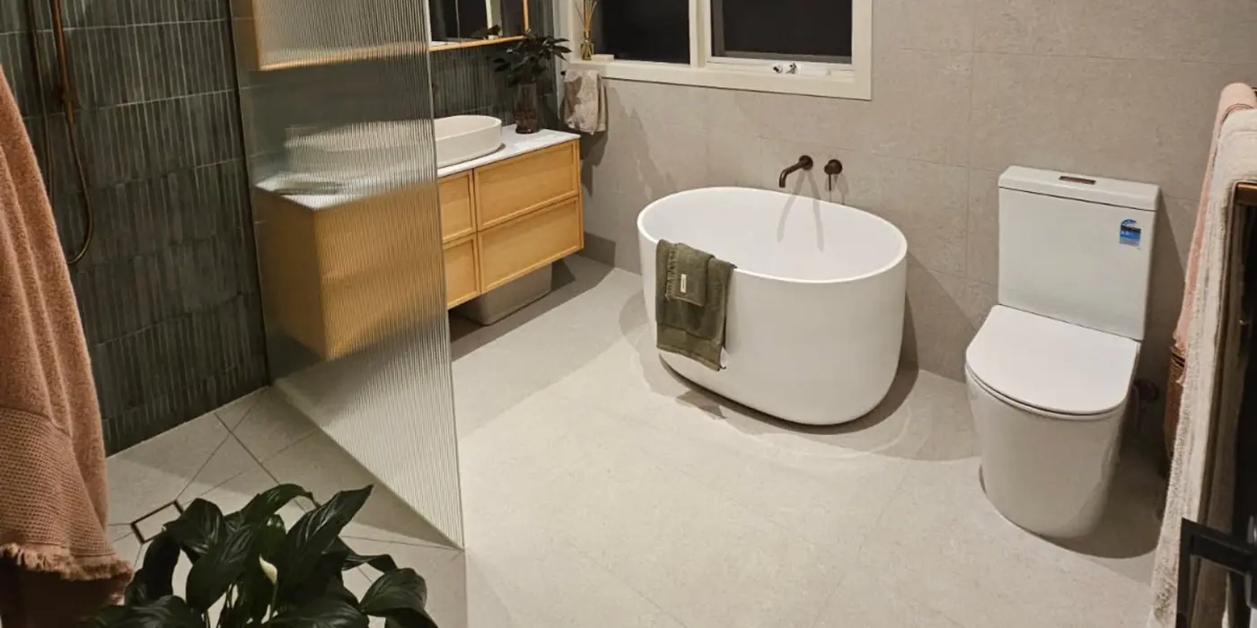 Finished bathroom with a freestanding bath and wall-faced toilet