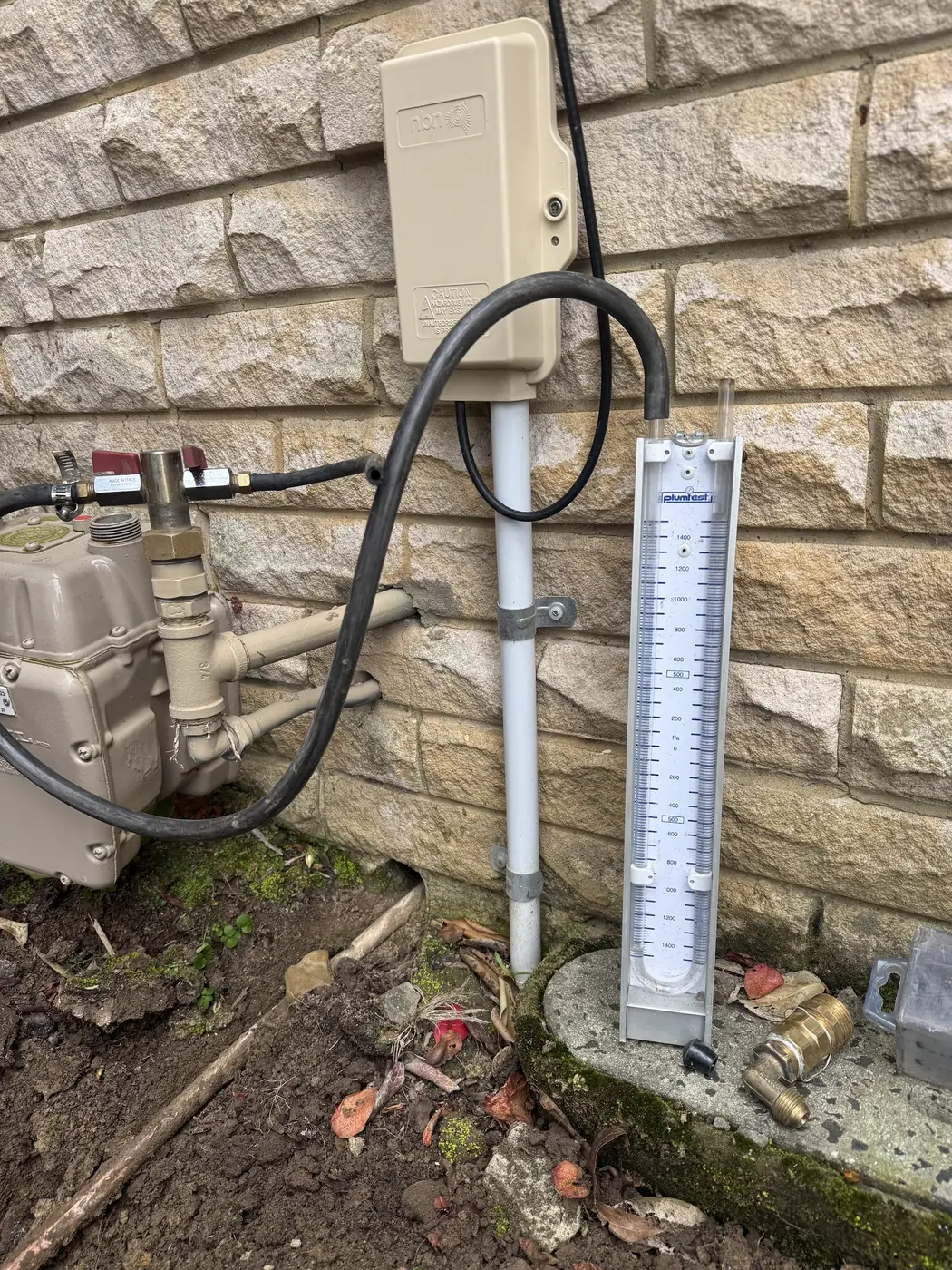 Gas meter with new pipework on a sandstone wall