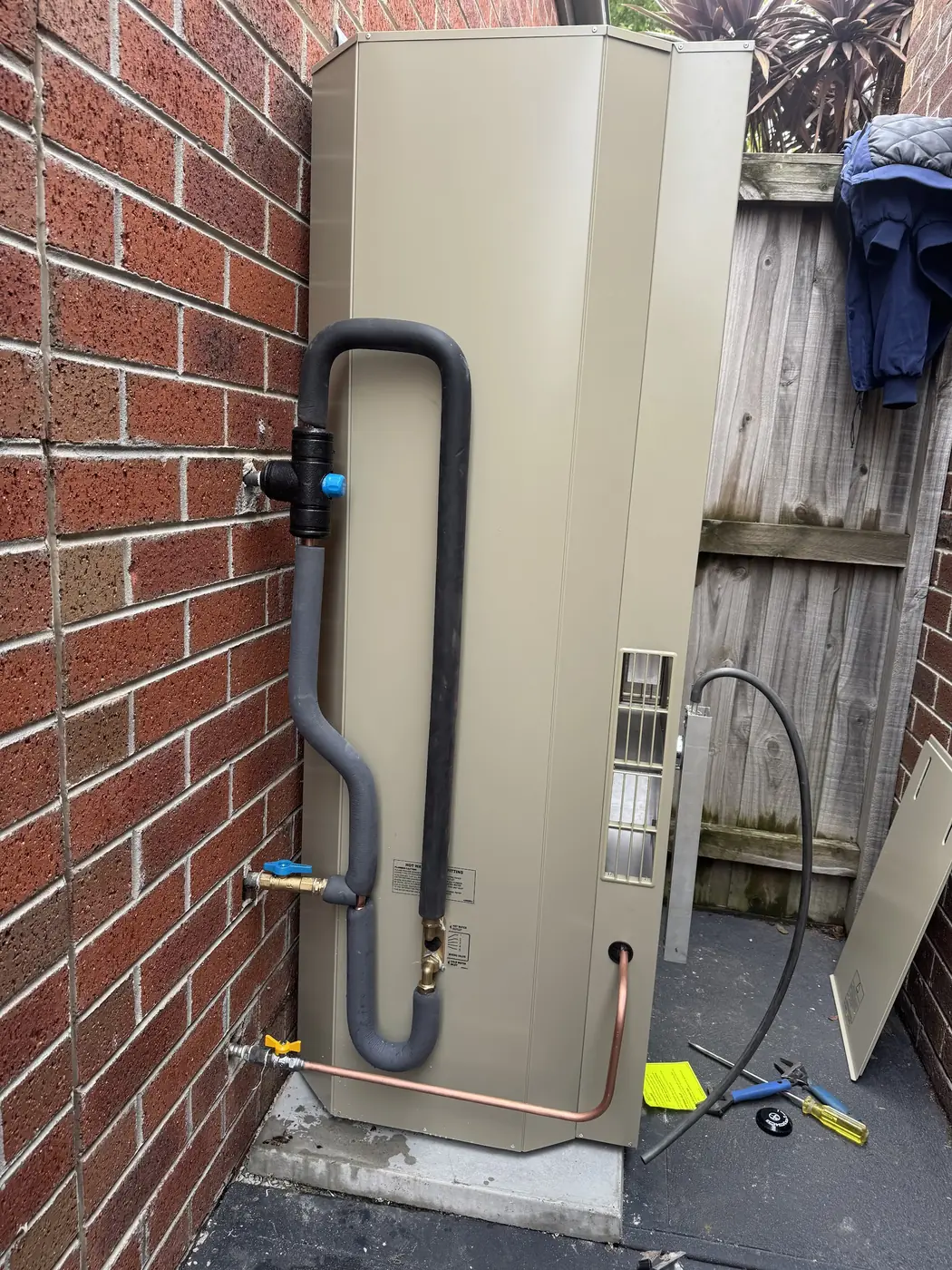 New hot water unit installed by Aquaflex against a brick wall