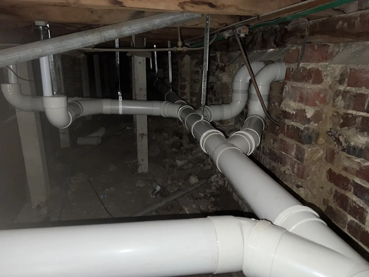 New white PVC sewer pipework running under a house floor