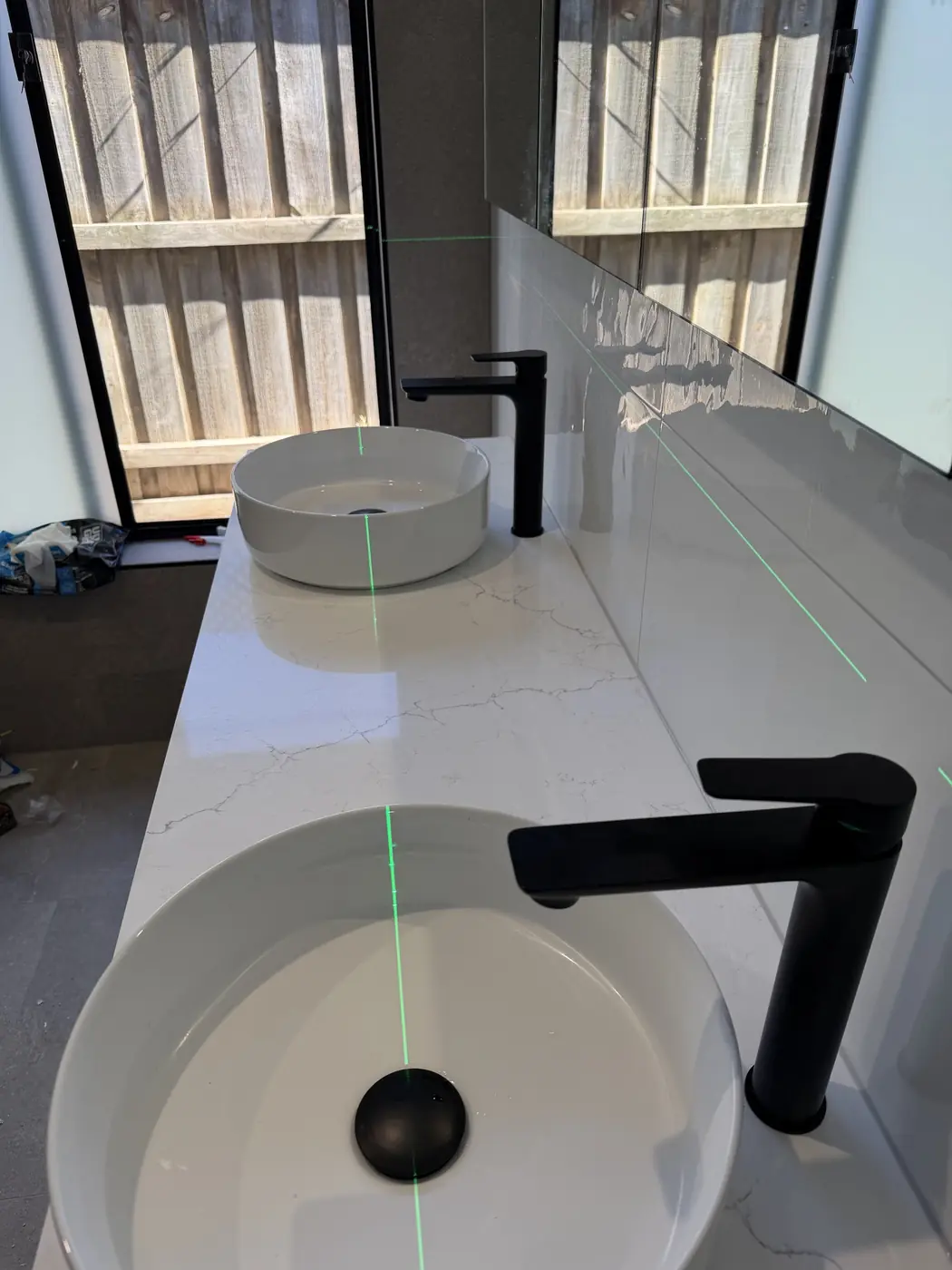 Vanity with a vessel basin and matte black tapware installed by Aquaflex