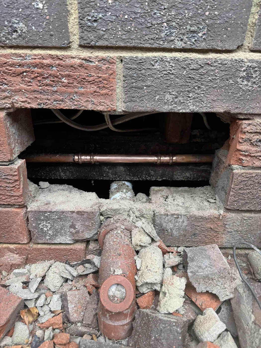 Brickwork opened up to repair a pipe inside the wall